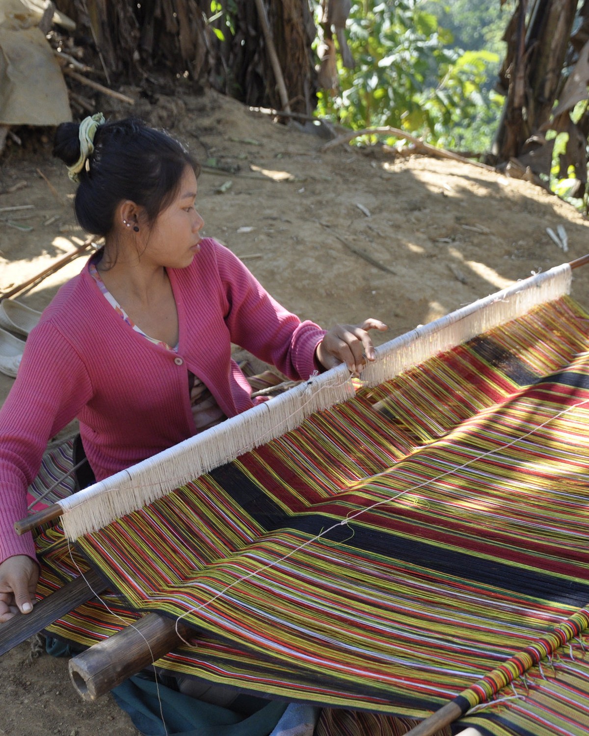 A weaver at her loom in a Mizoram village