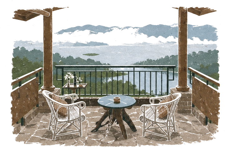 Illustration of a stone veranda with two cane chairs and a small table, looking over a misty lake and hills