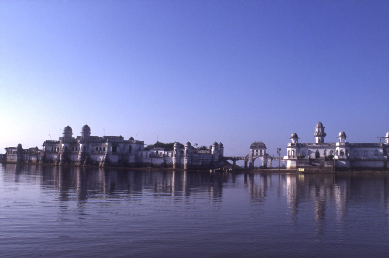 White domed palace rising straight from a lake, arches and towers mirrored in still water