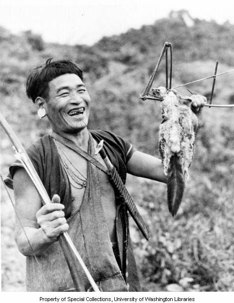 Inyong, an Adi man with a chin tattoo, with a squirrel from his trap, Ramgong, ca. 1954