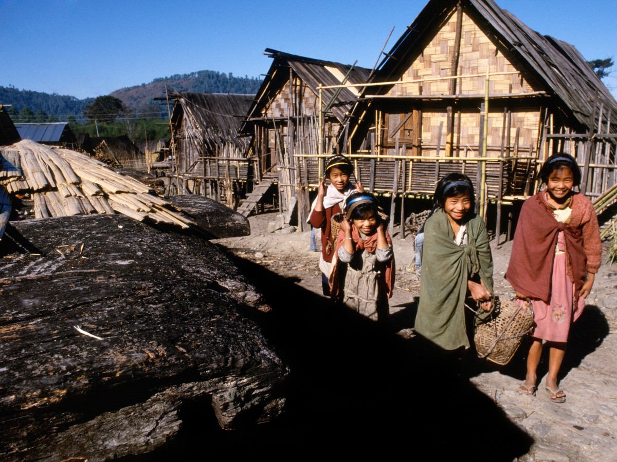 Children walking between timber stilt houses in an Apatani village