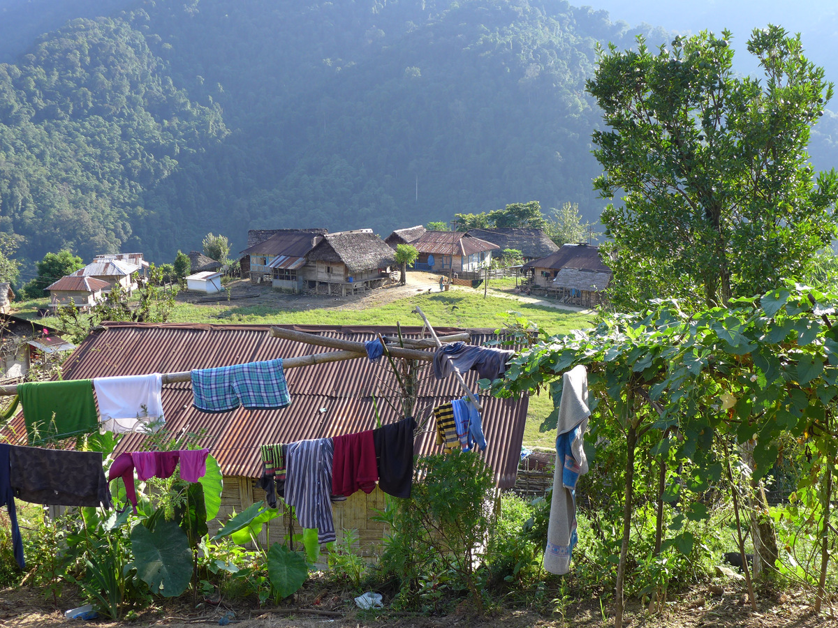 Houses and washing lines in Kuging village below forested hills