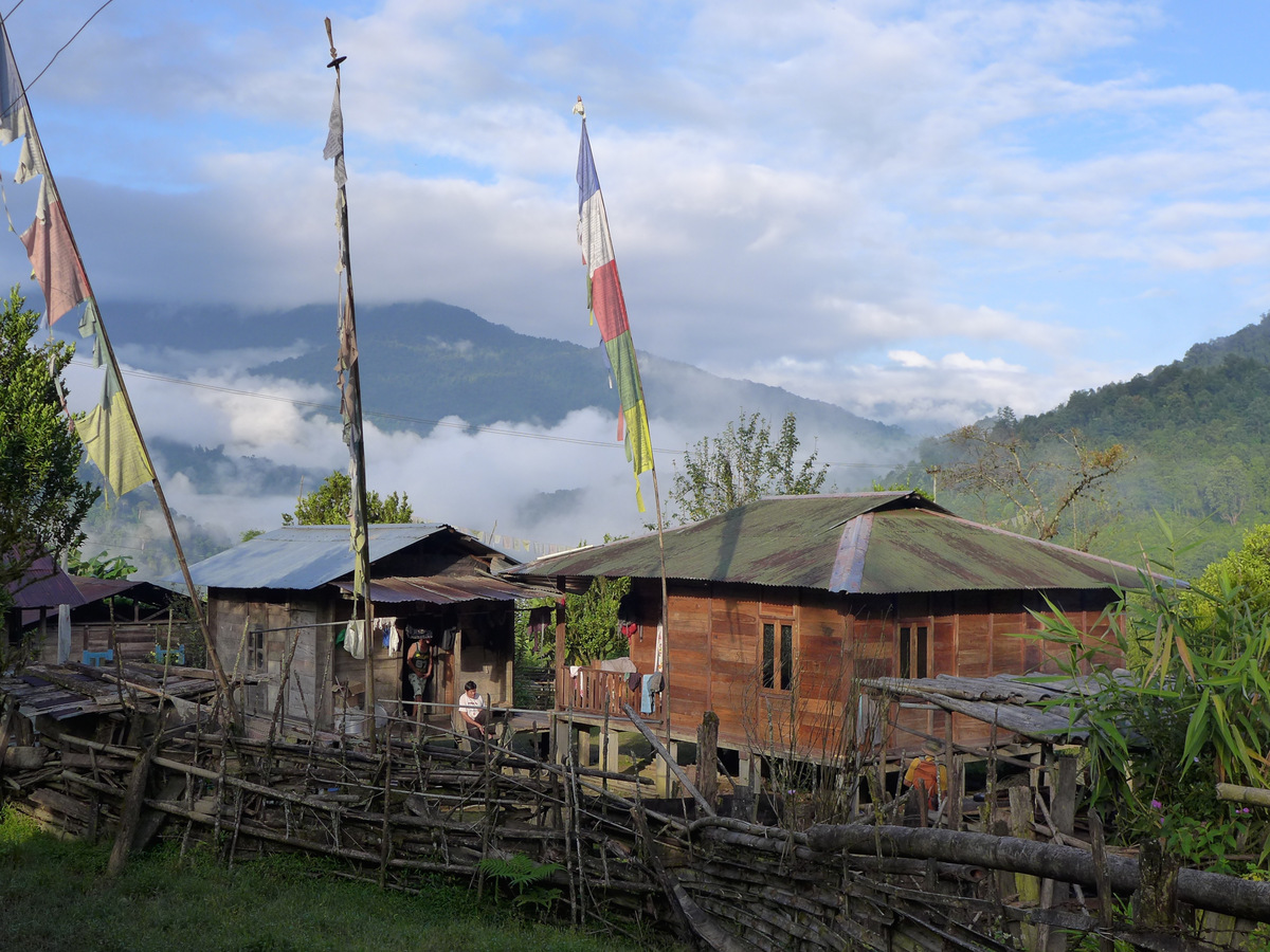 Wooden Memba houses and prayer flags in Mankota village