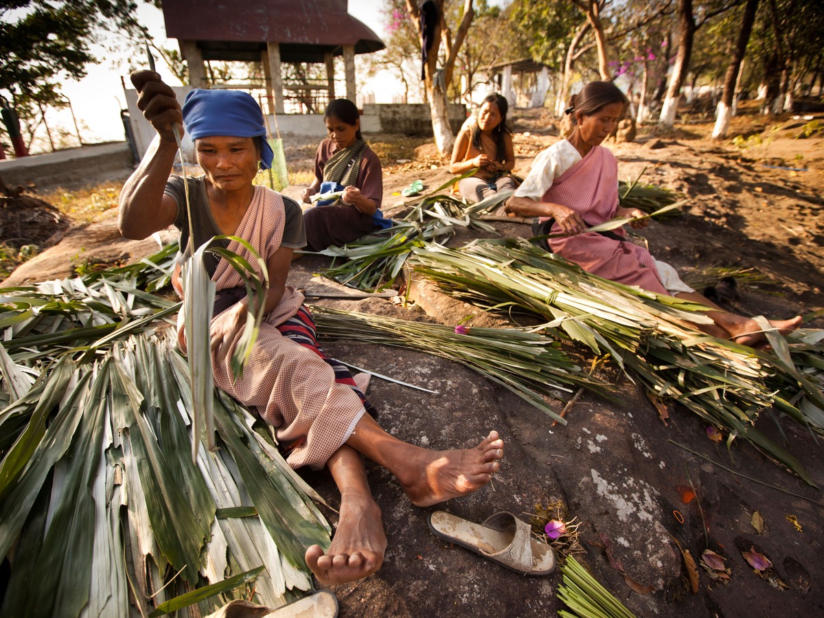 Villagers weaving palm thatch together