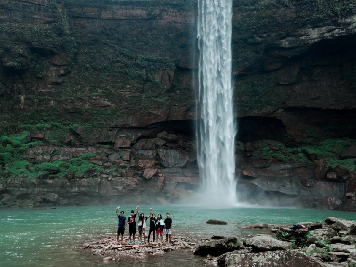 A group standing on rocks below Phe Phe Falls