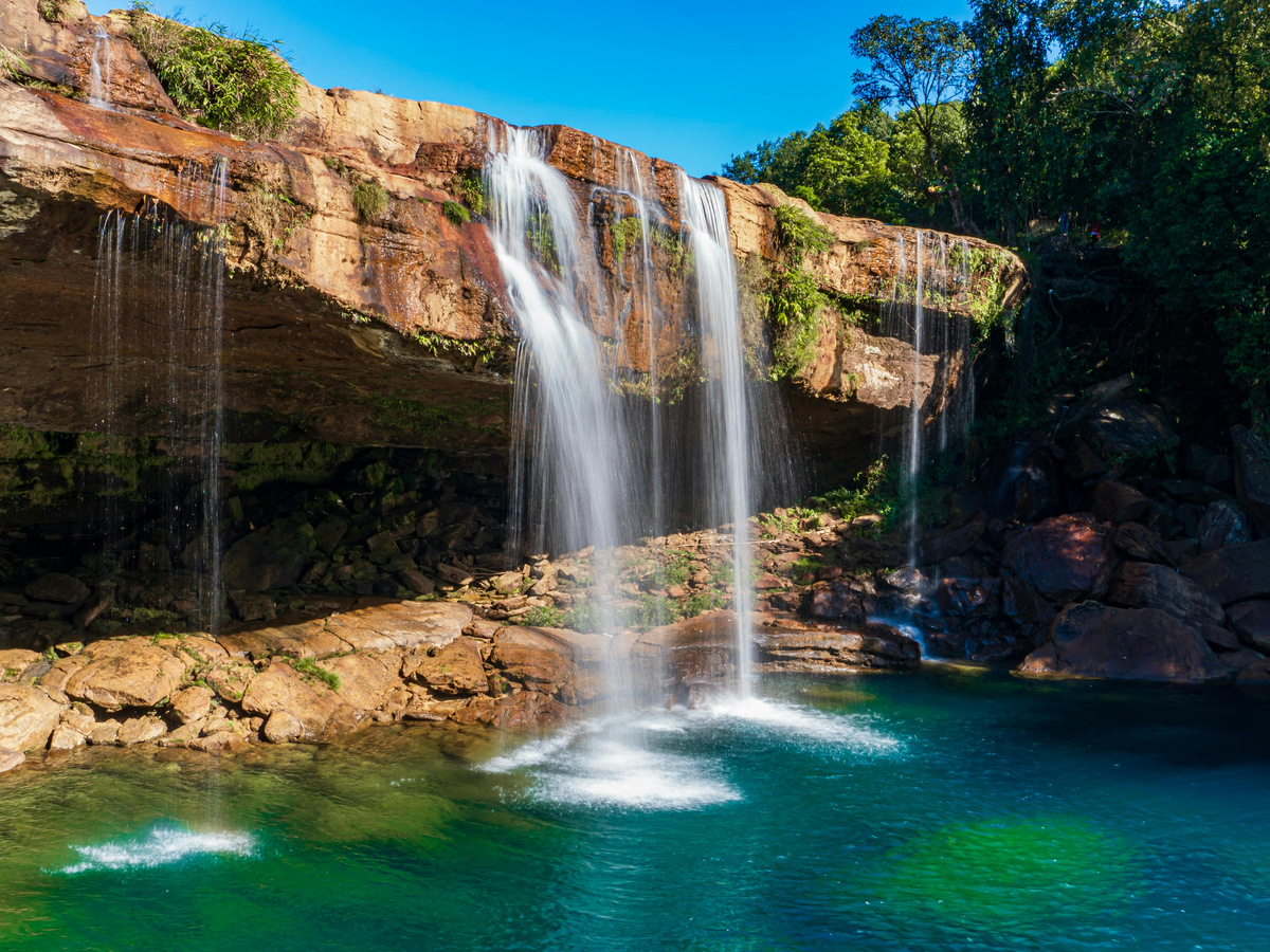 A wide waterfall pouring into a clear turquoise pool