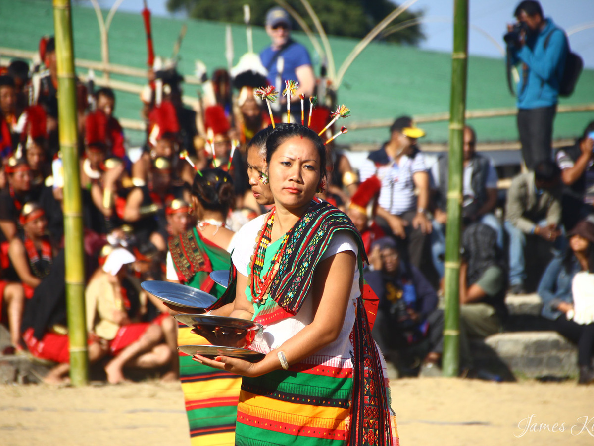 A woman in traditional dress performing a plate dance at the Hornbill Festival