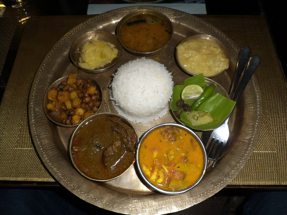 An Assamese thali with rice, fish curry and small side dishes