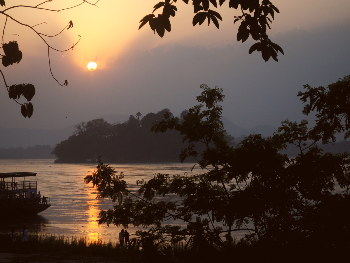 Sunset over the Brahmaputra with a boat on the water