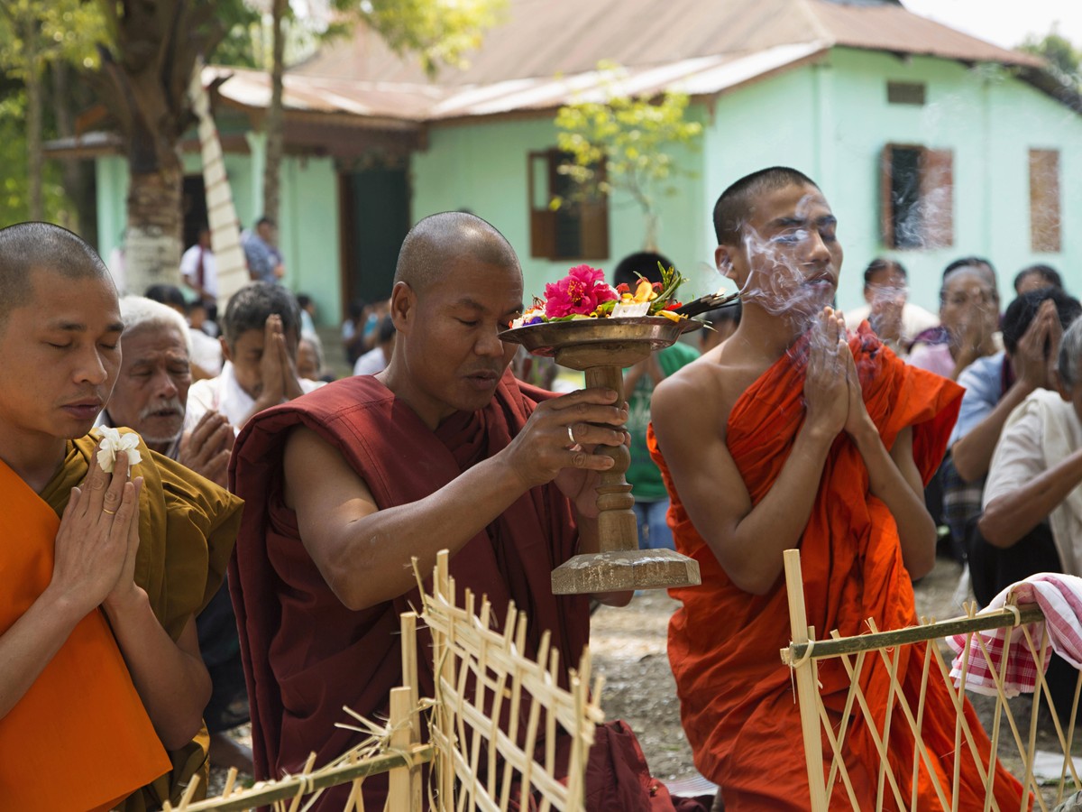 Monks and villagers at a ceremony outside a village monastery