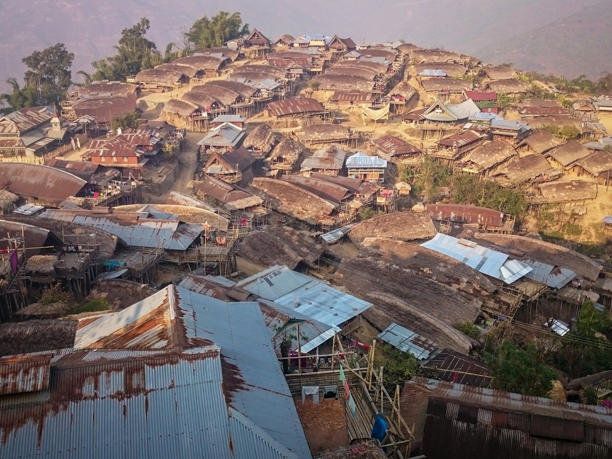 Tin roofs of a hill village packed along a ridge