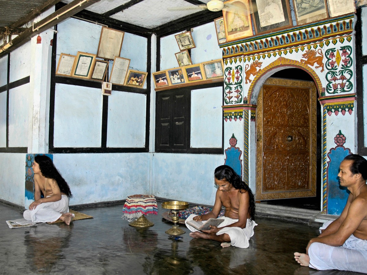 Monks inside the painted prayer hall of an Assamese satra