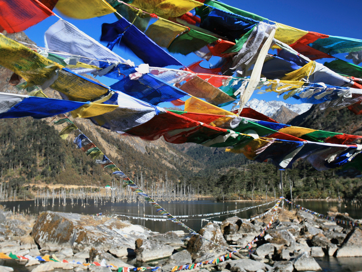 Prayer flags strung over a high mountain lake